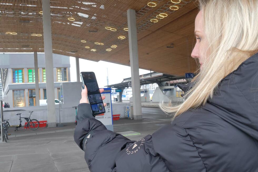 Bettina Meier-Bickel holding a mobile phone playing "Artspotting"