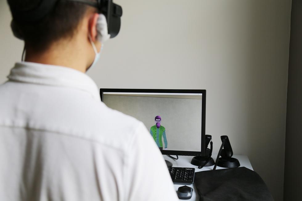 Man with VR glasses sitting in fron of a screen