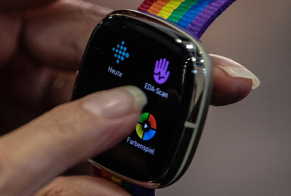 Woman holding a fitbit watch in her hand