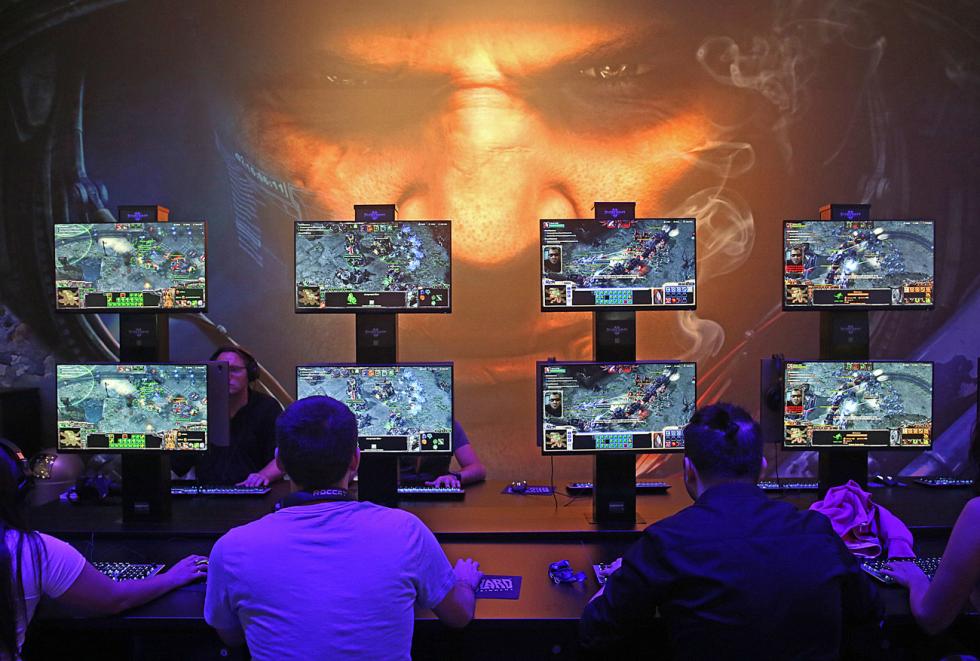 People gaming against the artificial intelligence AlphaStar on various screens