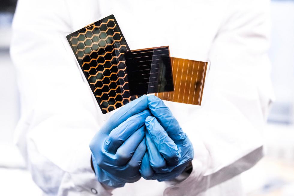 A researcher holding ultra-thin and flexible solar cells in his hands