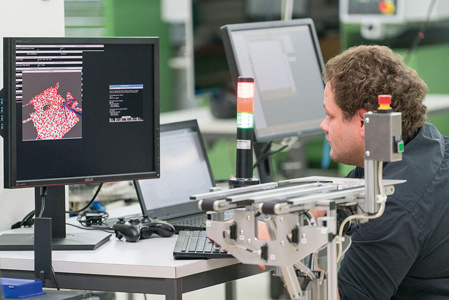 A man in front of a computer screen in the lab