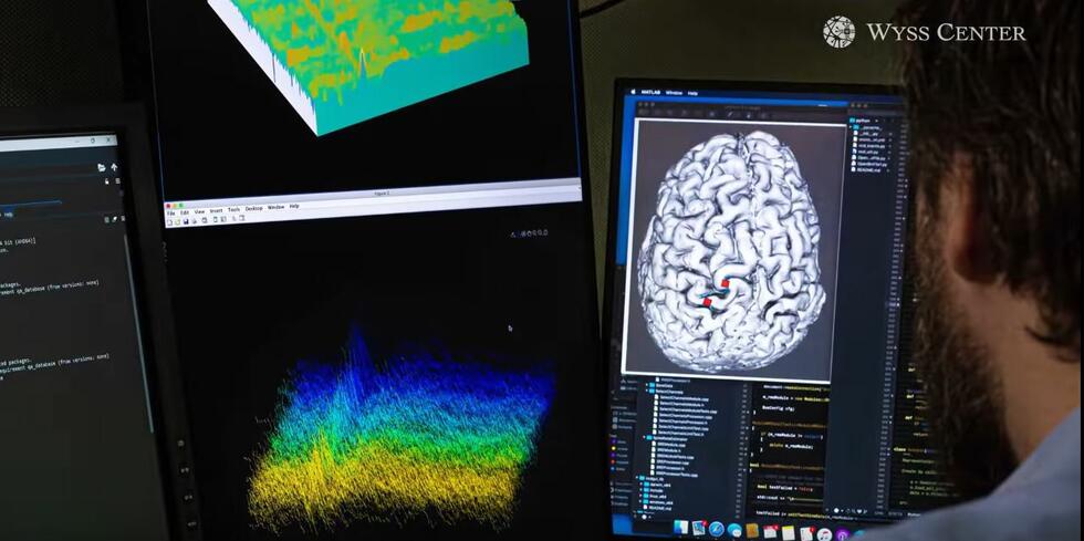 Scientist looking at a screen showing a brain