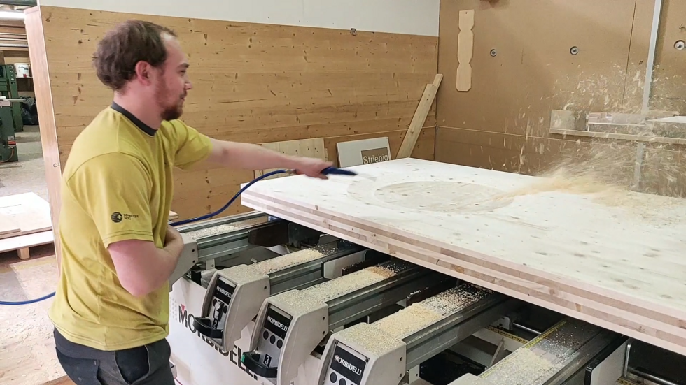 A carpenter provides a thick wooden panel with pea-shaped indentations