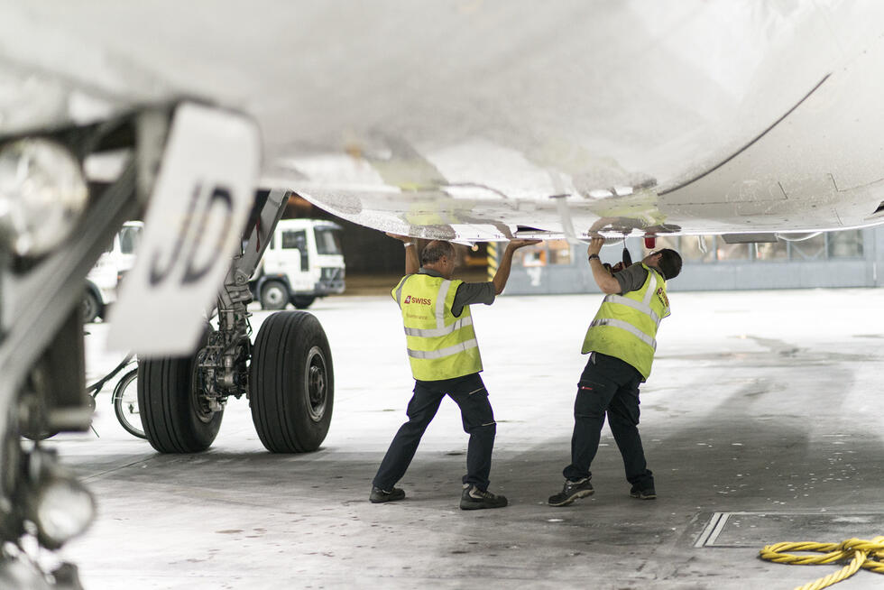 Mechanics performing maintenance work on an aircraft