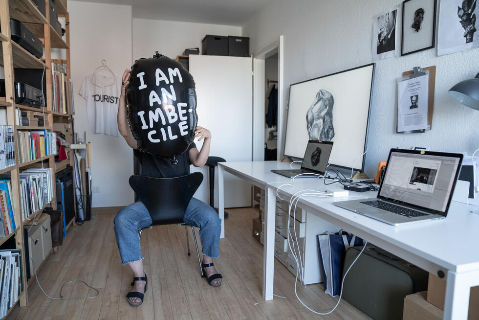 Esther Hunziker in her studio with balloon in front of her face