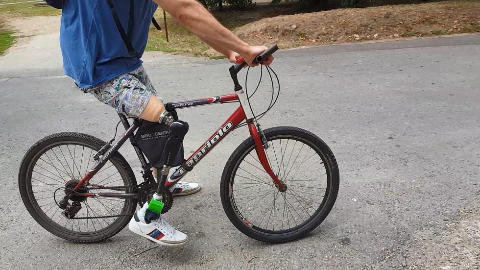 Man with leg prosthesis riding a bike